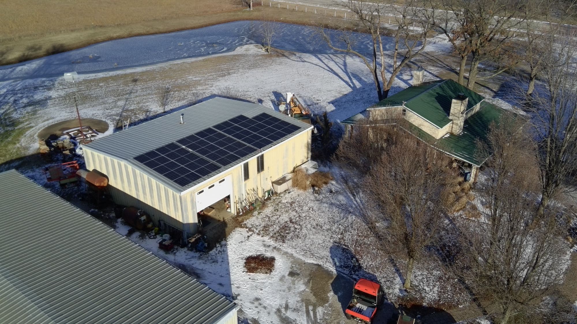 Home solar — rooftop array on an outbuilding beside the house, rural southeast Kansas